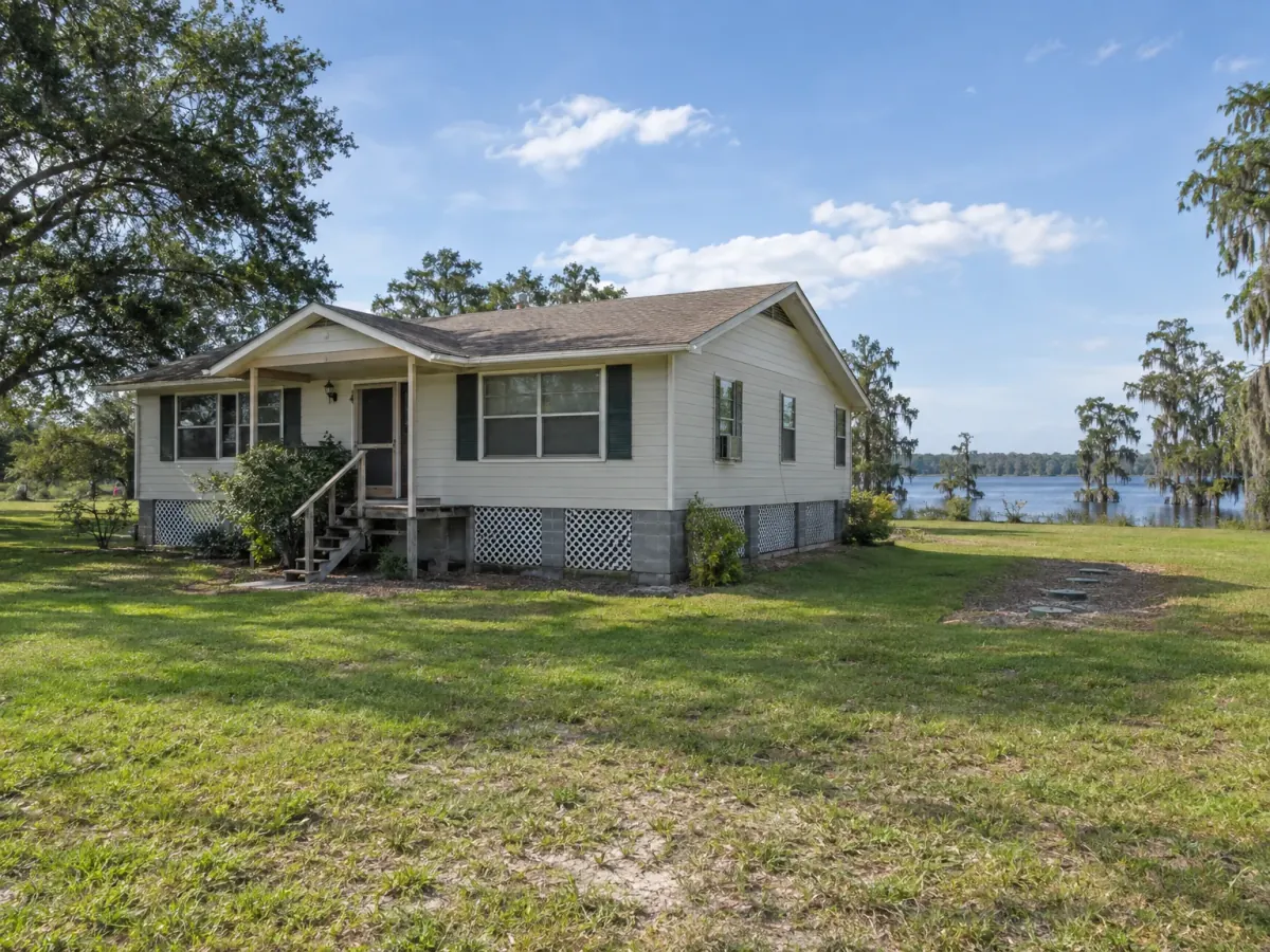 Mold remediation in St. Cloud, FL · illustrative image of rural home raised on a crawl space near a cypress-lined lake